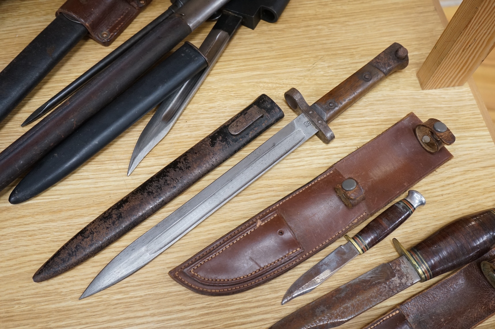 A 1907 bayonet by Wilkinson in its steel mounted leather scabbard, another similar with leather frog, two small British bayonets, a Continental bayonet, and two assorted hunting knives (7)
